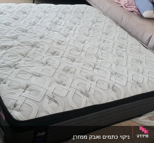 מזרן על רצפה עם כלי ניקוי לידו